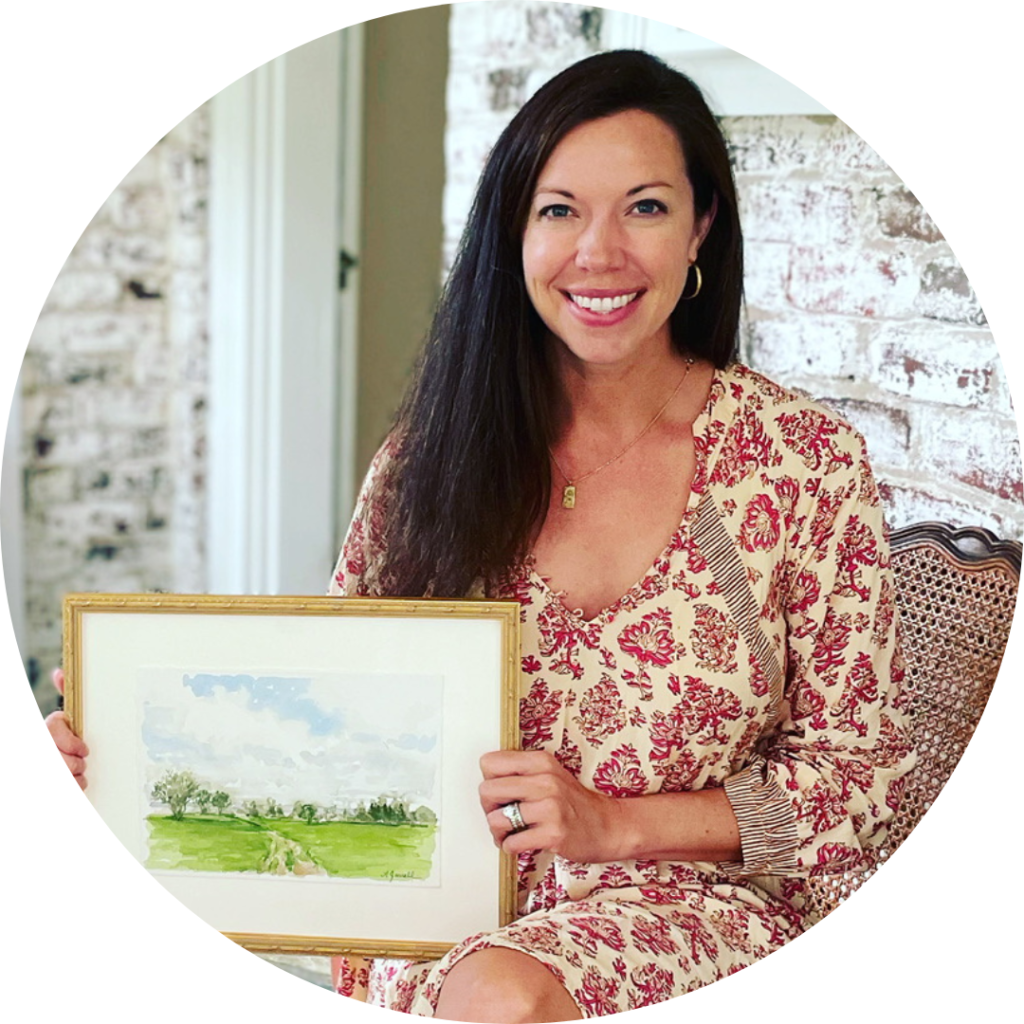 Woman with long dark hair and a red and cream dress holding up a landscape painting and smiling