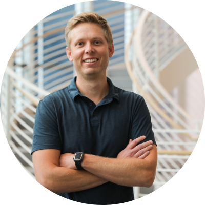 Blonde man with his arms crossed smiling at the camera