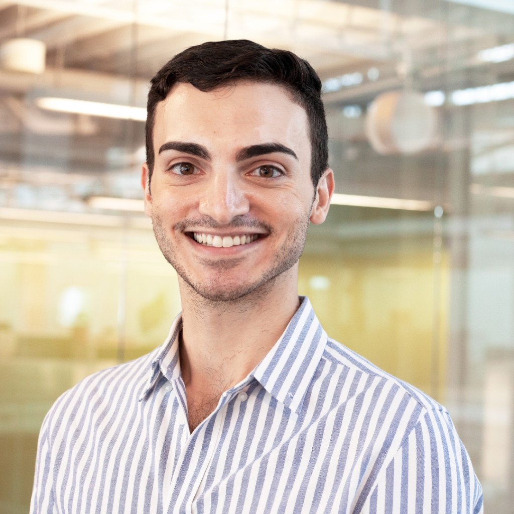 Photo of man in striped shirt smiling at camera