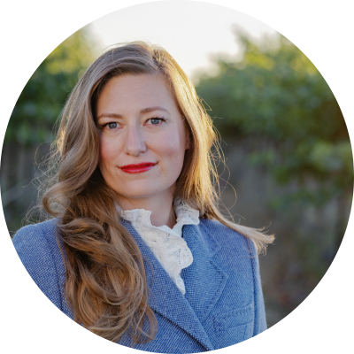 Woman with brown hair and a blue suit smiling at the camera