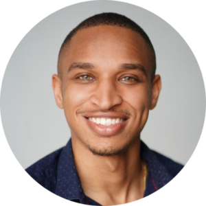 Photo of a man wearing a navy blue shirt smiling at the camera