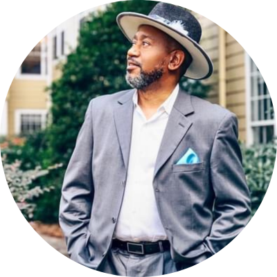 Man wearing a gray suit and a hat looking to the left