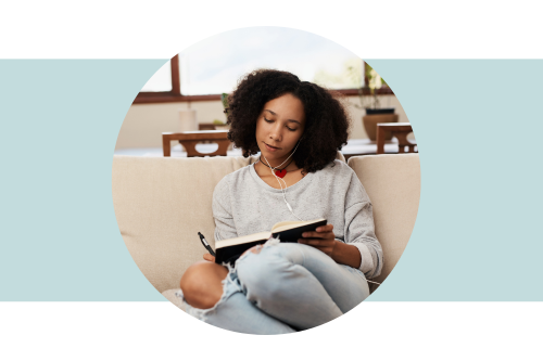 Woman sitting on a sofa writing in a journal
