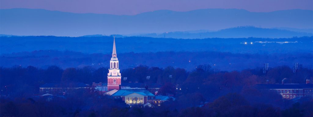 The bell tower of Wait Chapel rises over the Wake Forest campus at dusk