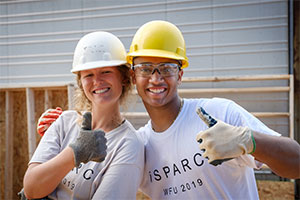 Wake Forest students in the SPARC pre-orientation program lay out and install pre-made wall sections at a Habitat for Humanity build.