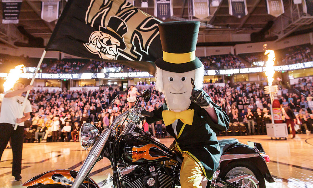 The Demon Deacon mascot takes to the court on his motorcycle.