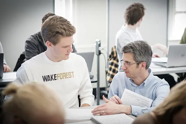 A student receiving advice from his professor in a Computer Science class