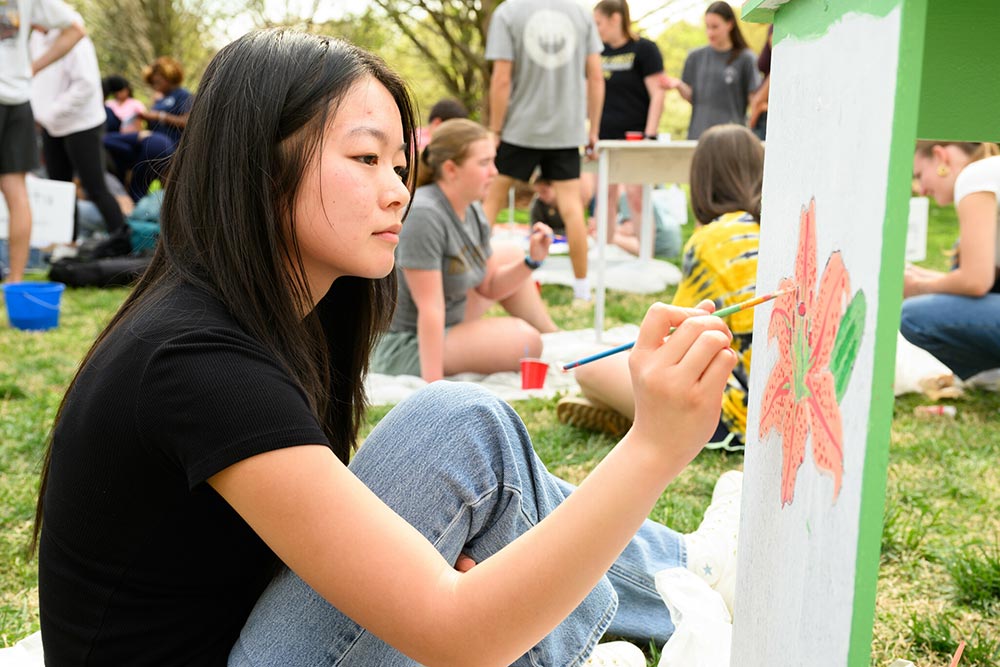 Wake Forest University students paint desks alongside local school children at Davis Field.