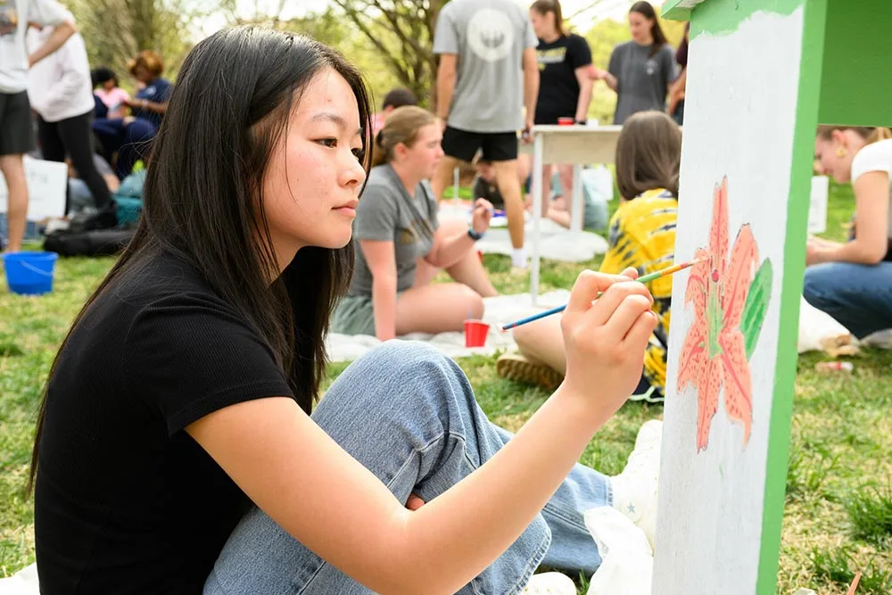 Wake Forest University students paint desks alongside local school children at Davis Field.