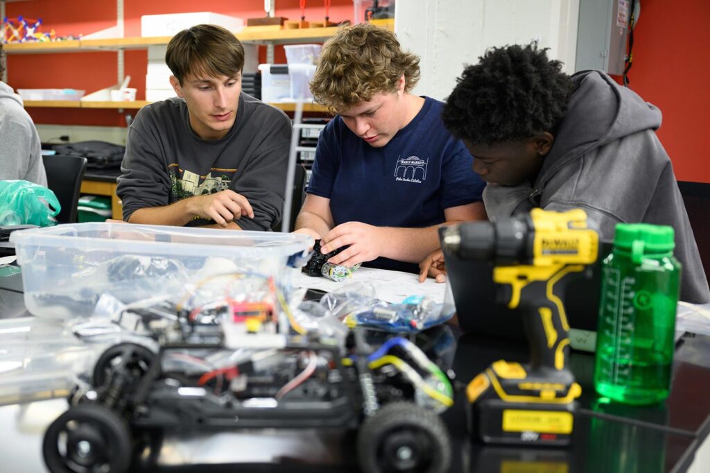 Students build a robotic car in their engineering class.