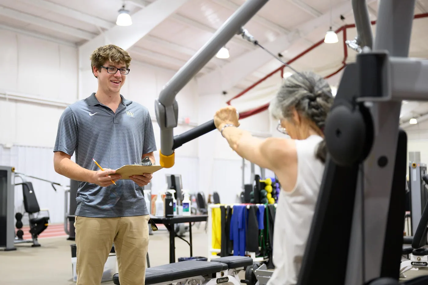 A Wake Forest University student Health & Exercise Science major and URECA Scholar, Kyle Alves works with research participants as they go through the high intensity intervention exercises at the Health & Exercise Science Clinical Research Center
