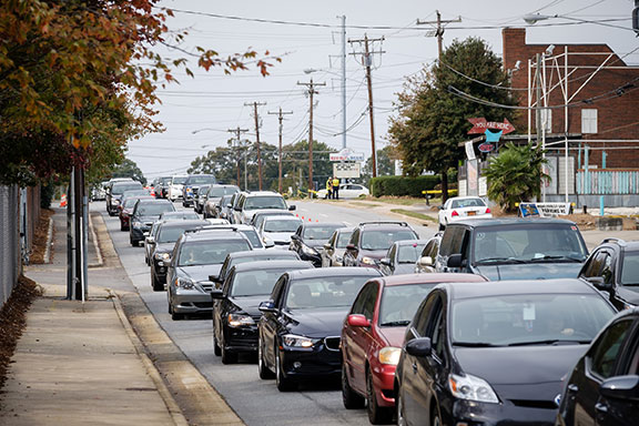 Long line of people and cars surround the coliseum.