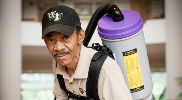 custodian using backpack vacuum