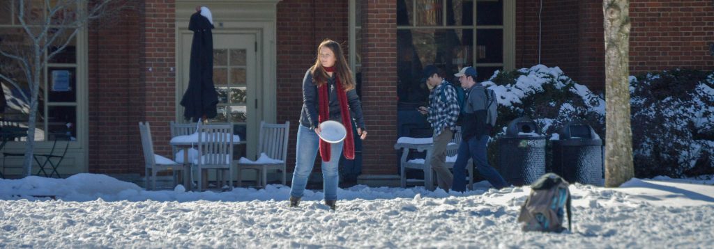 student playing frisbee on a snow day