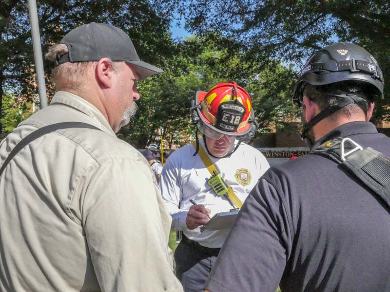 firefighter rescue team gets scenario info from WFU employees for confined space training drill