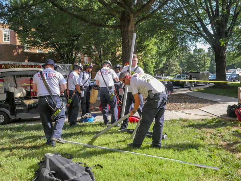 fire department team sets up equipment for confined space training drill