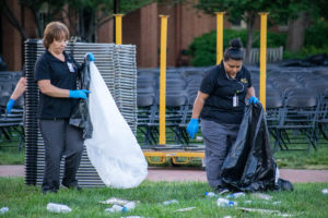 custodial staff picking up chairs form commencement the day before