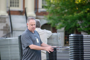 jim coffey helping pull up commencement chairs