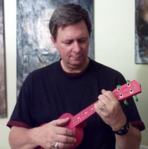 Kurt Shaw playing a pink ukulele in Paris, France.