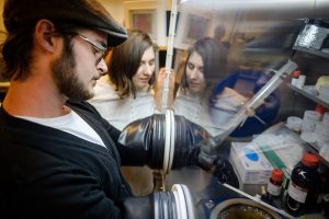 Sophomore physics major Robby Bradford works with a glove box as Dr. Oana Jurchescu looks on.