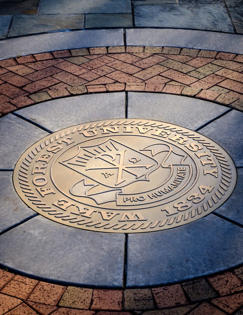 Gold university seal embedded in brick walkway