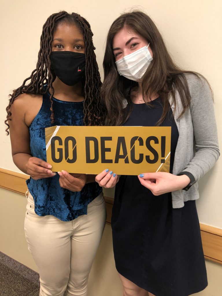 Brianna Aaron and Ruby Klein hold a Go Deacs sign after winning the ACC Debate Tournament