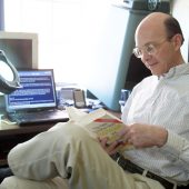 WFU history professor Michael Hughes reds a book in his office on campus.