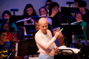 David Hagy wears a flesh colored costume while conducting during the Halloween concert.