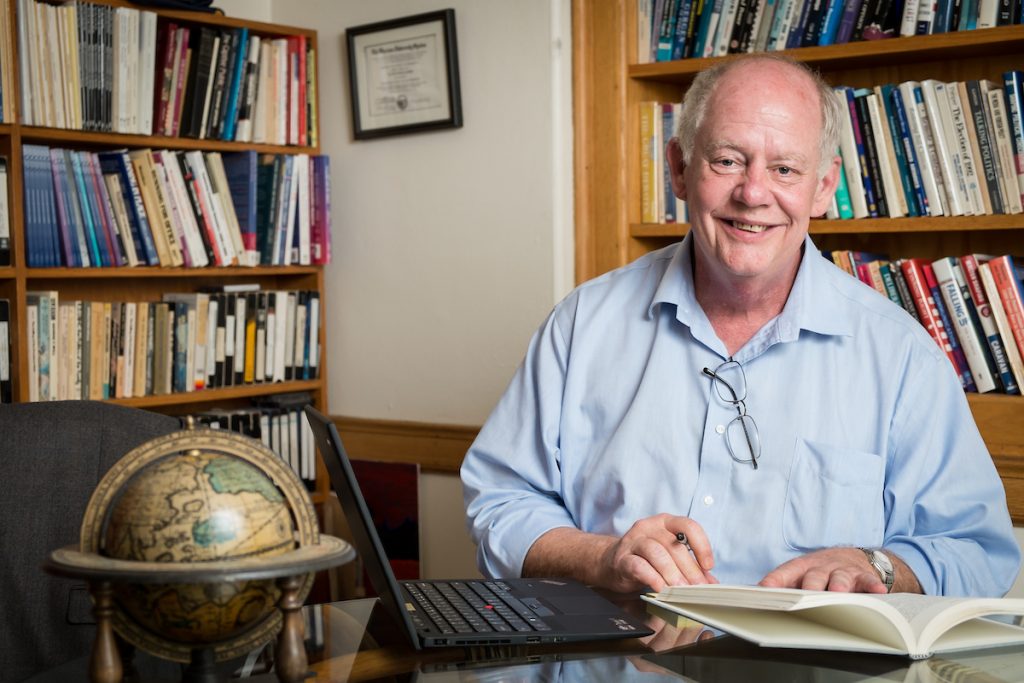 Communication professor Allan Louden sits at his desk in his Carswell Hall office.