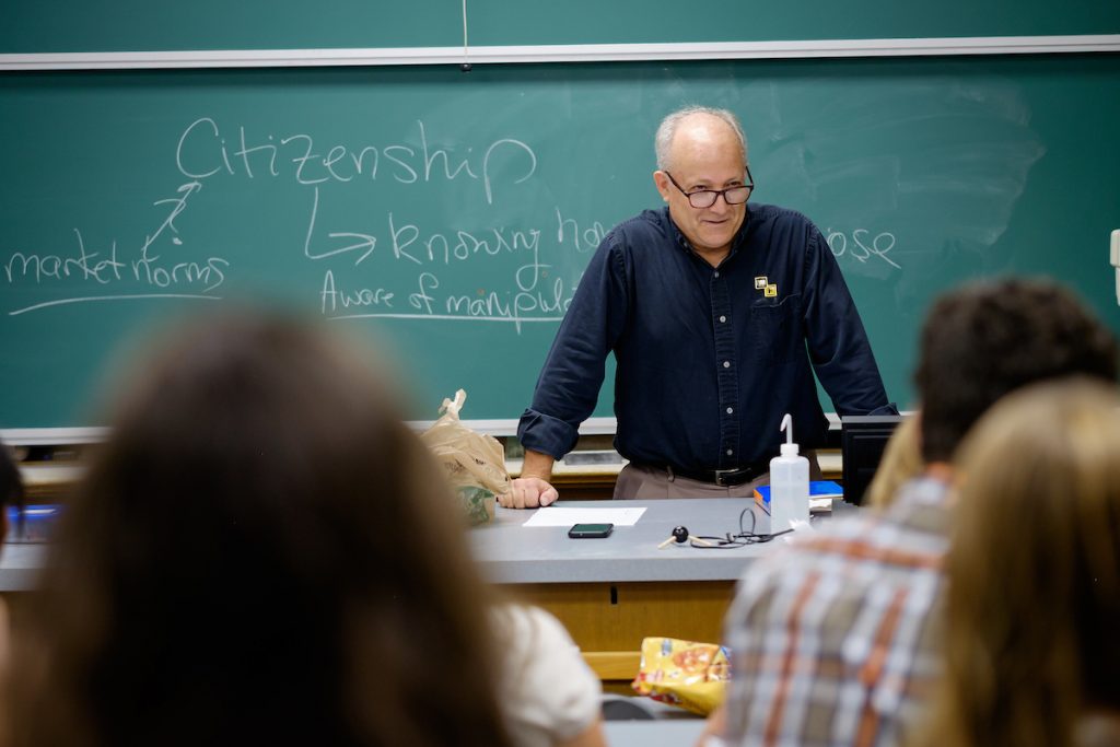 Dr. Al Rives stands at the blackboard while students ask questions