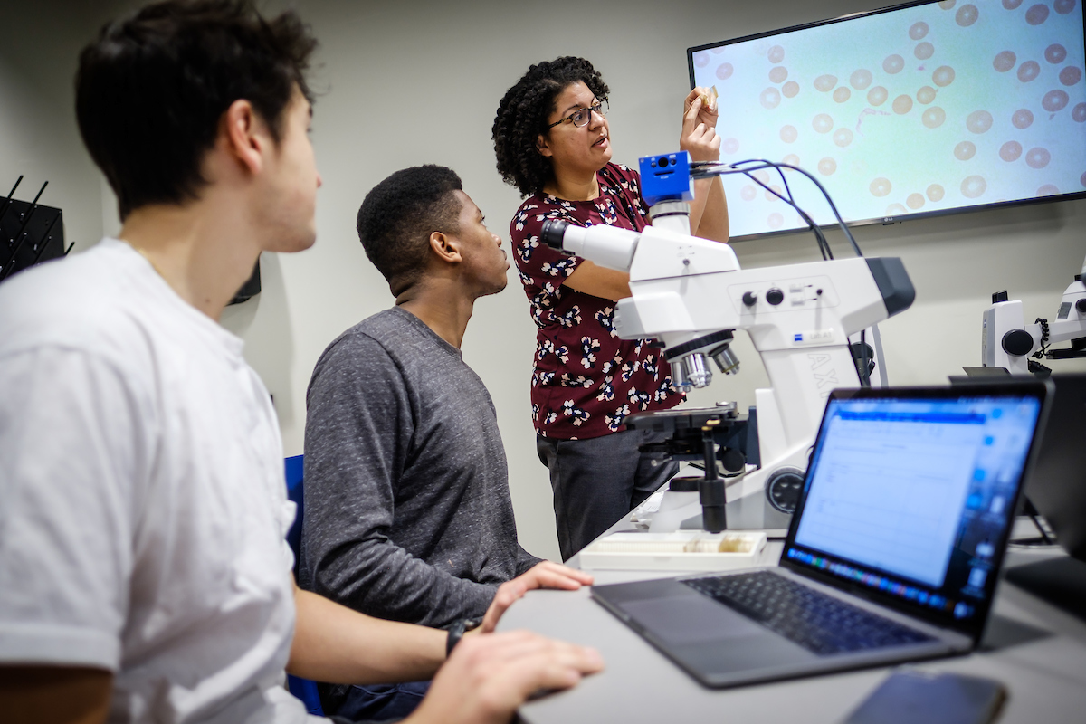 Wake Forest biology students work in the microscopy lab viewing flagellar parasites in the Bio 321 Parasitology class taught by professor Regina Cordy and graduate teaching assistant Scott Cory, in Winston Hall on Tuesday, January 29, 2019. Cordy helps Chi-Chi Ogbonna ('20) and Kess McSwain look at slides in their microscope.