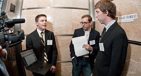 Sophomore Ben Comer (at left) and junior Brett Apter (at right) describe their new Web site, MySavu.com, to one of the judges in the Babcock School's annual Elevator Competition during a two-minute elevator ride at the Wachovia Center in downtown Winston-Salem on March 28.