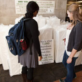 Students look at a pile of 7,000 Styrofoam boxes in the Fresh Food Company that will be replaced by reusable to-go boxes.