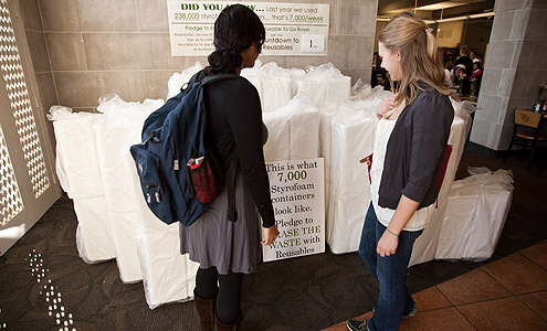 Students look at a pile of 7,000 Styrofoam boxes in the Fresh Food Company that will be replaced by reusable to-go boxes.