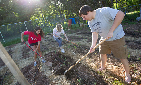 As part of their spring biology class, Emily Earle, Kris Frantz and Nick Conte work in the campus garden to learn about plant physiology, sustainability and community service.