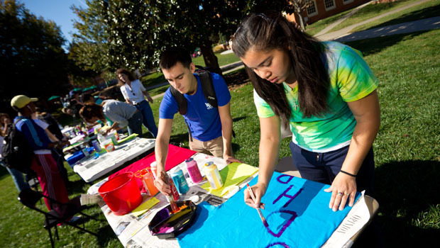First-year student Keirah Carmichael (right) paints a shirt to hang on the clothesline.