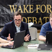 Debate coach Jarrod Atchison (center) works with debaters Alexis Shklar ('14, left) and Andrew McCarty ('12) in the debate squad room in Carswell Hall.