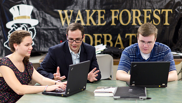 Debate coach Jarrod Atchison (center) works with debaters Alexis Shklar ('14, left) and Andrew McCarty ('12) in the debate squad room in Carswell Hall.