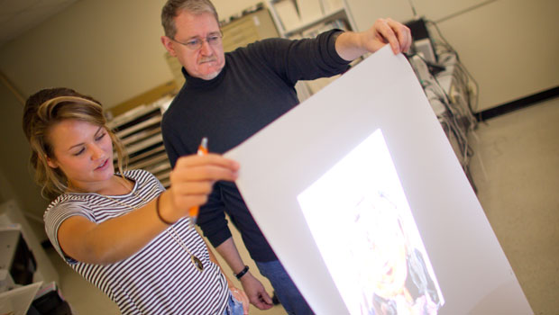 Assoc. Prof. John Pickel helps a student with her video art project.