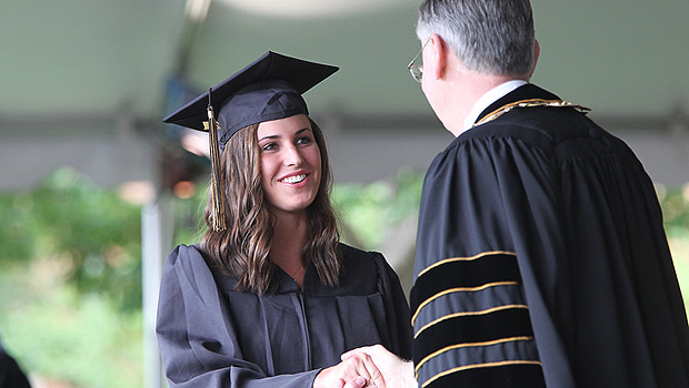 President Hatch shakes hands with a graduate.