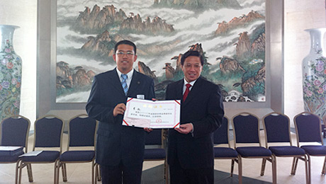 Chinese Ambassador Zhang Yesui (right) presents the award to Yuan Li.