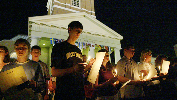 Student holding candles in front of Wait Chapel
