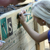 LENS participant Jordan Sullivan colors in letter on sign.