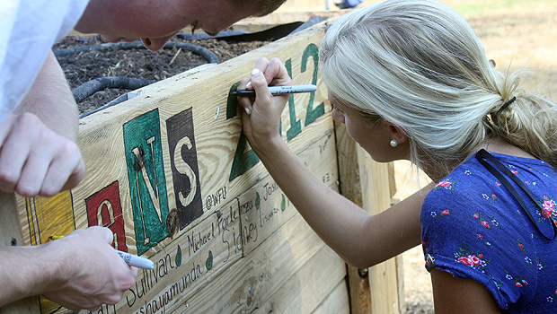 LENS participant Jordan Sullivan colors in letter on sign.