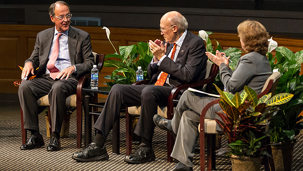 Alan Simpson and professor Katy Harriger applaud a point by Erskine Bowles (left).