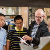 Wake Forest chemistry professor Uli Bierbach talks with staff member Linda Tuttle along with graduate students Xin Qiao (left) and Song Ding.