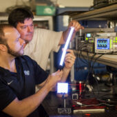 Wake Forest University physics professor David Carroll works with graduate student Greg Smith on new FIPEL lighting technology.