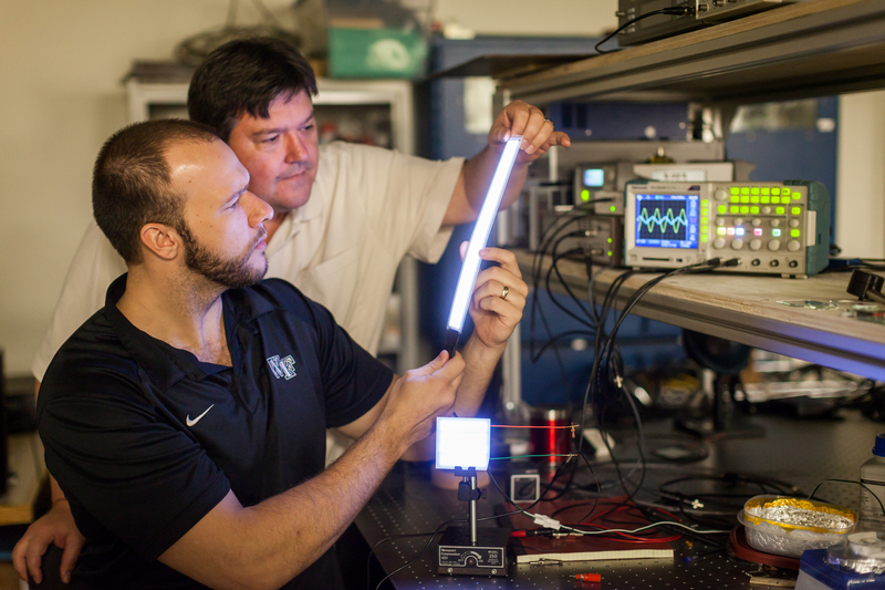 Wake Forest University physics professor David Carroll works with graduate student Greg Smith on new FIPEL lighting technology.