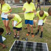 Hanes Middle School students attending the Power Up! summer camp, taught by Wake Forest physics faculty and graduate students, interact with the Hybrid Sterling Energy Generator (HySterE) panel.