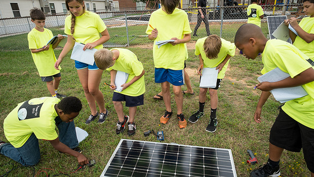 Hanes Middle School students attending the Power Up! summer camp, taught by Wake Forest physics faculty and graduate students, interact with the Hybrid Sterling Energy Generator (HySterE) panel.